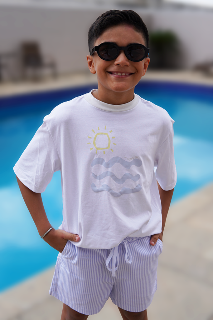 modelo usando look olivo kids, sendo camiseta lá vem o sol e bermuda listras