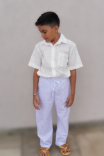 Criança vestindo calça listrada azul da Olivo Kids, look casual e camisa off white com fechamento por botões