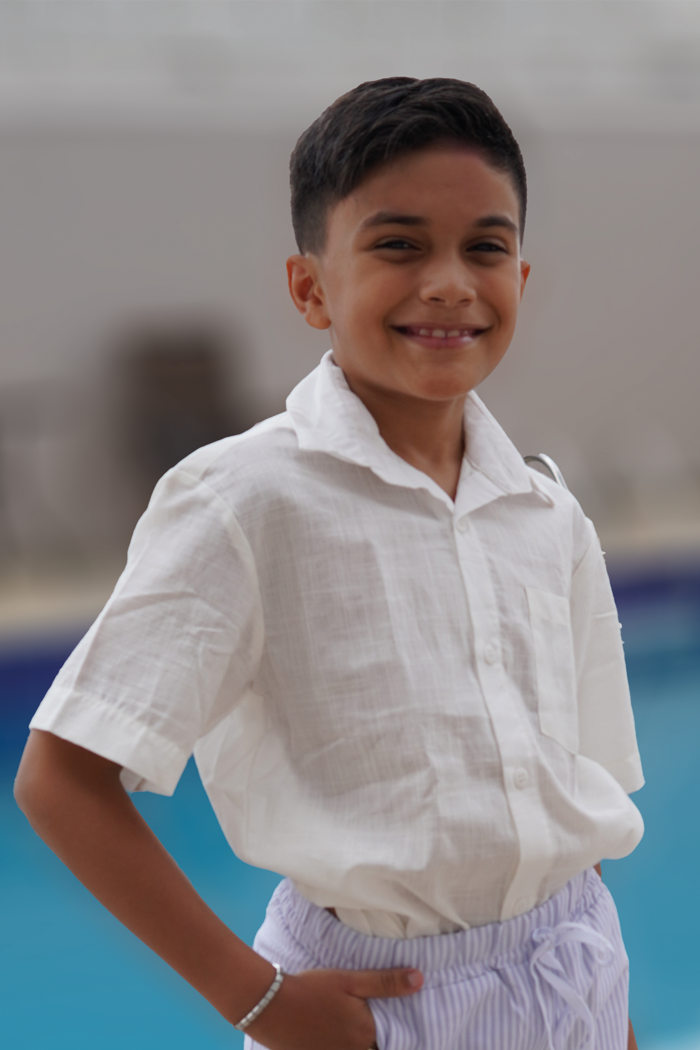 modelo usando Camisa infantil off white para meninos com ombro deslocado e botões frontais
